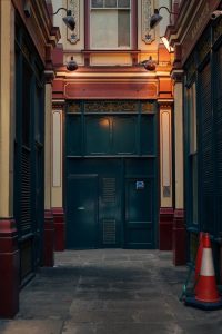 A moody alleyway in Leadenhall Market, London with vintage architecture and a traffic cone.